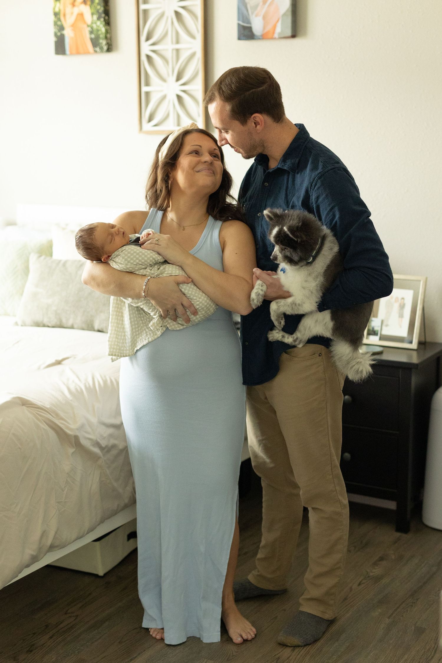 Photo of a family holding their dog and new baby taken during their in-home newborn session
