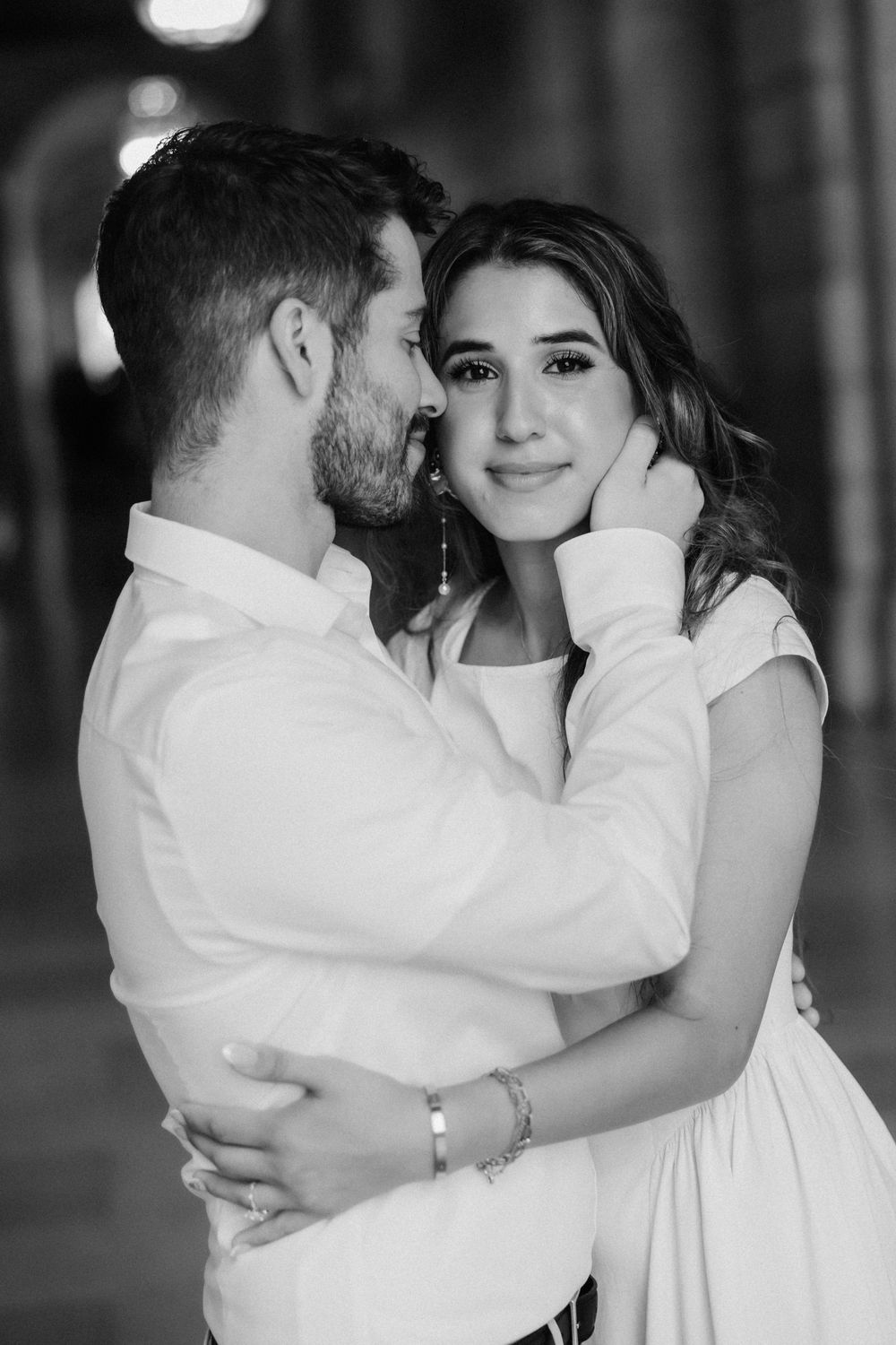 A romantic black and white portrait of a couple embracing in an intimate moment.