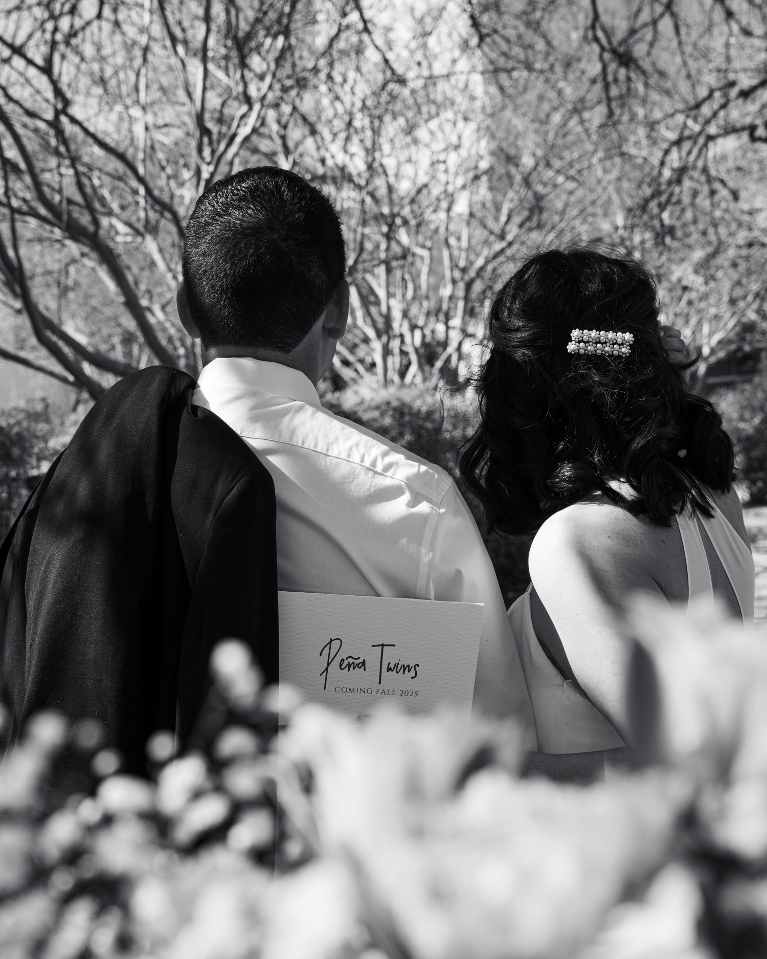 Black and white artistic photo of couple during pregnancy announcement picnic.