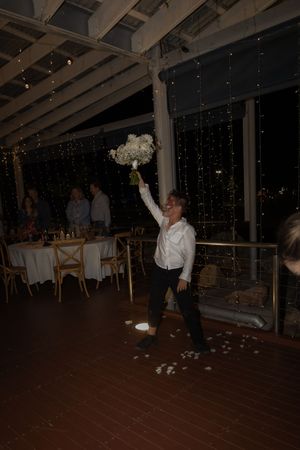 Indoor wedding reception venue with exposed beam ceiling and twinkle light decorations.