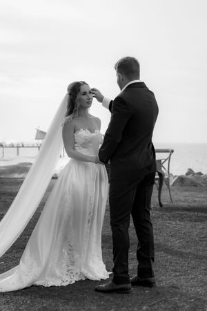 Black and white series of romantic wedding ceremony moments on coastal cliff.