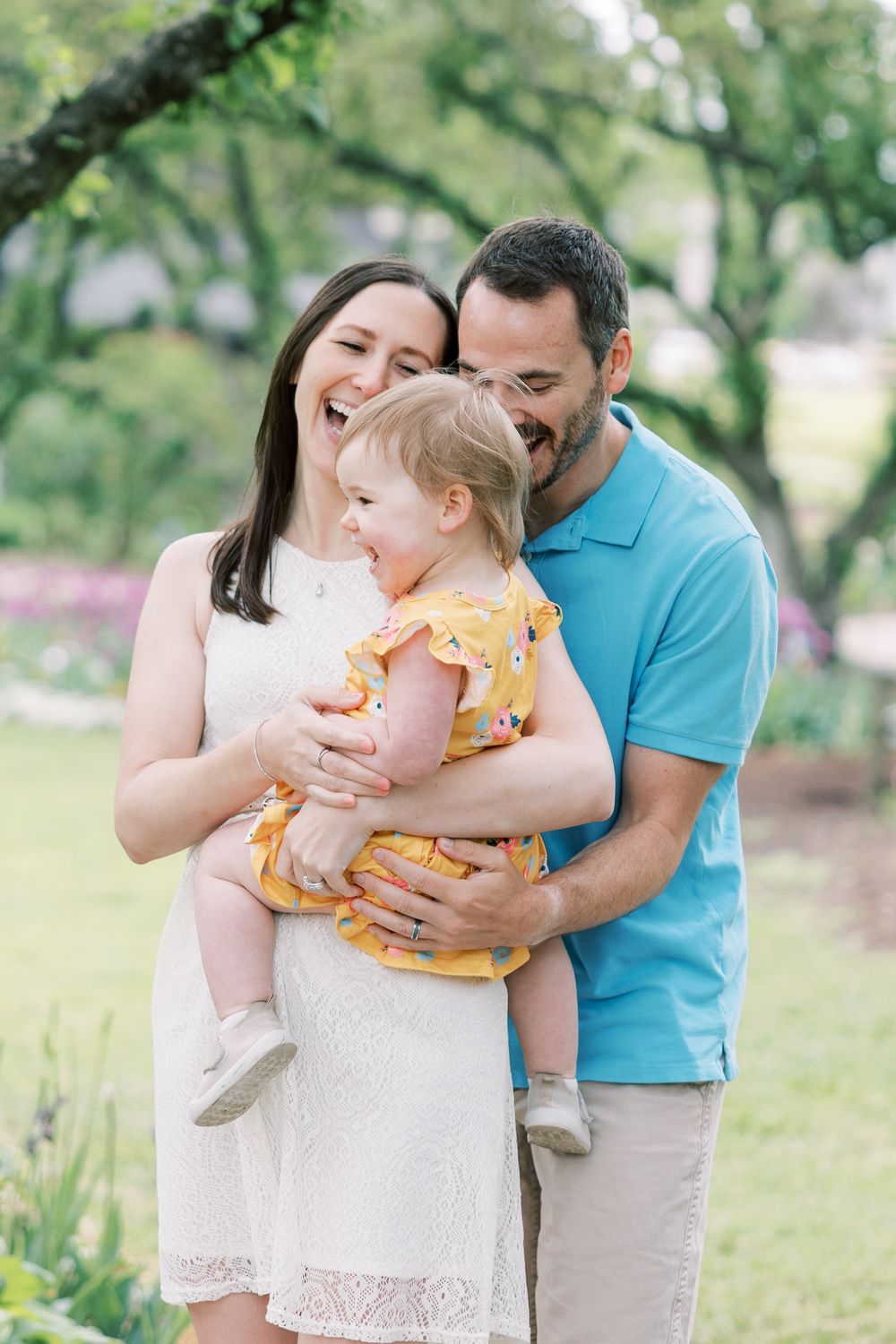 A family shares joyful moments together in a sunny garden while wearing spring casual attire.