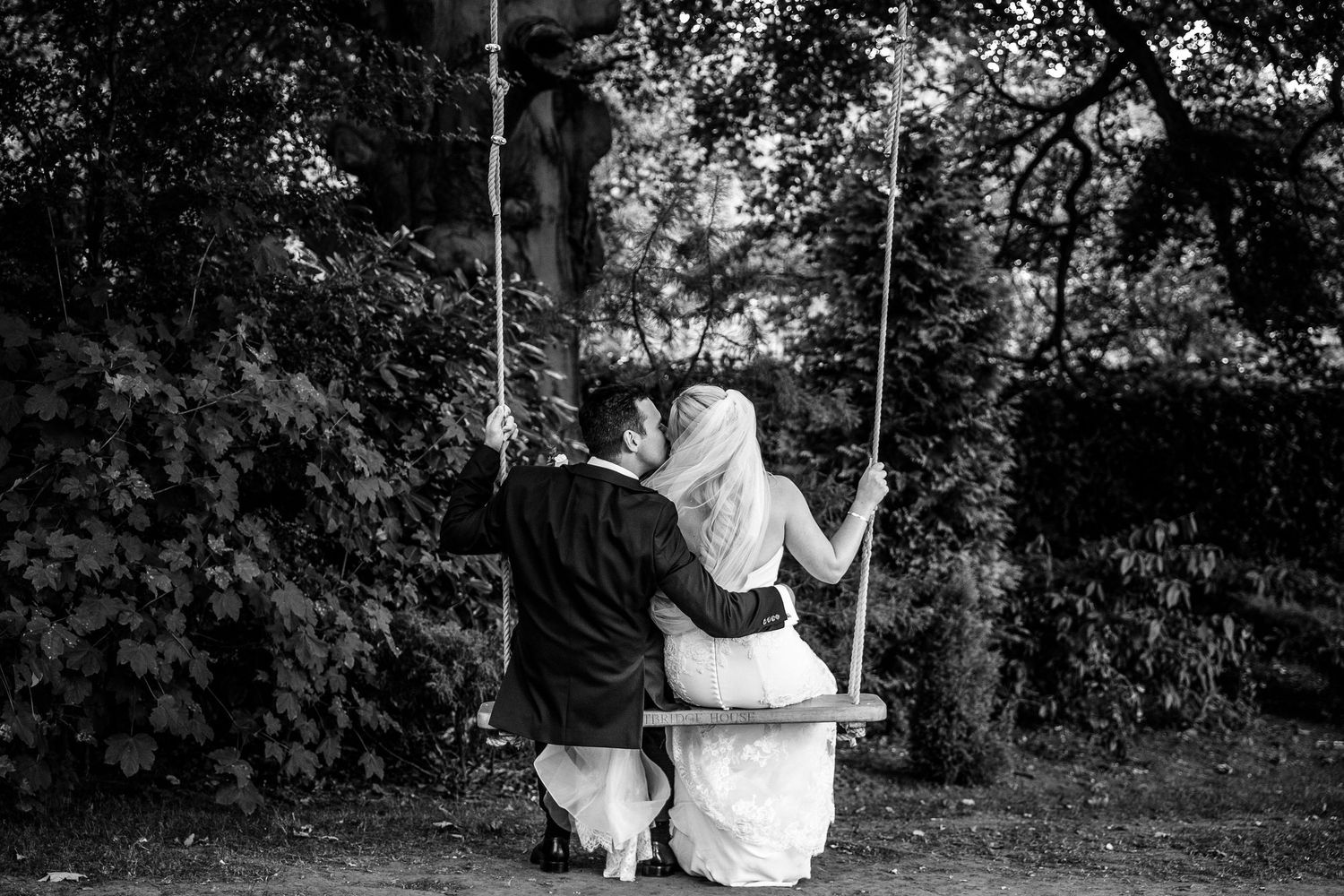 Romantic garden swing scene with flowing white wedding dress creating a dreamy atmosphere.