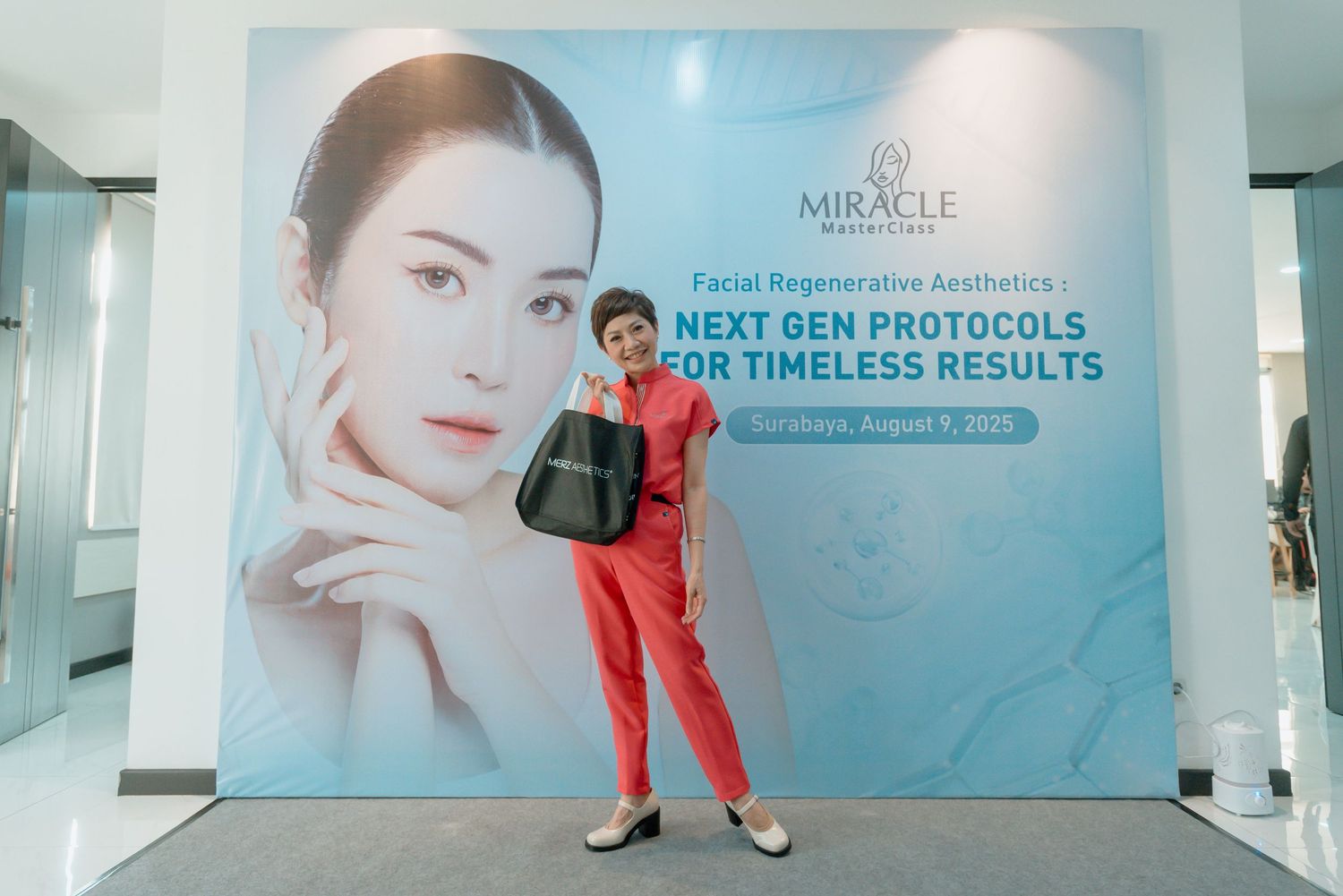 A person in a red outfit poses in front of a blue beauty clinic wall display with skincare advertisements.