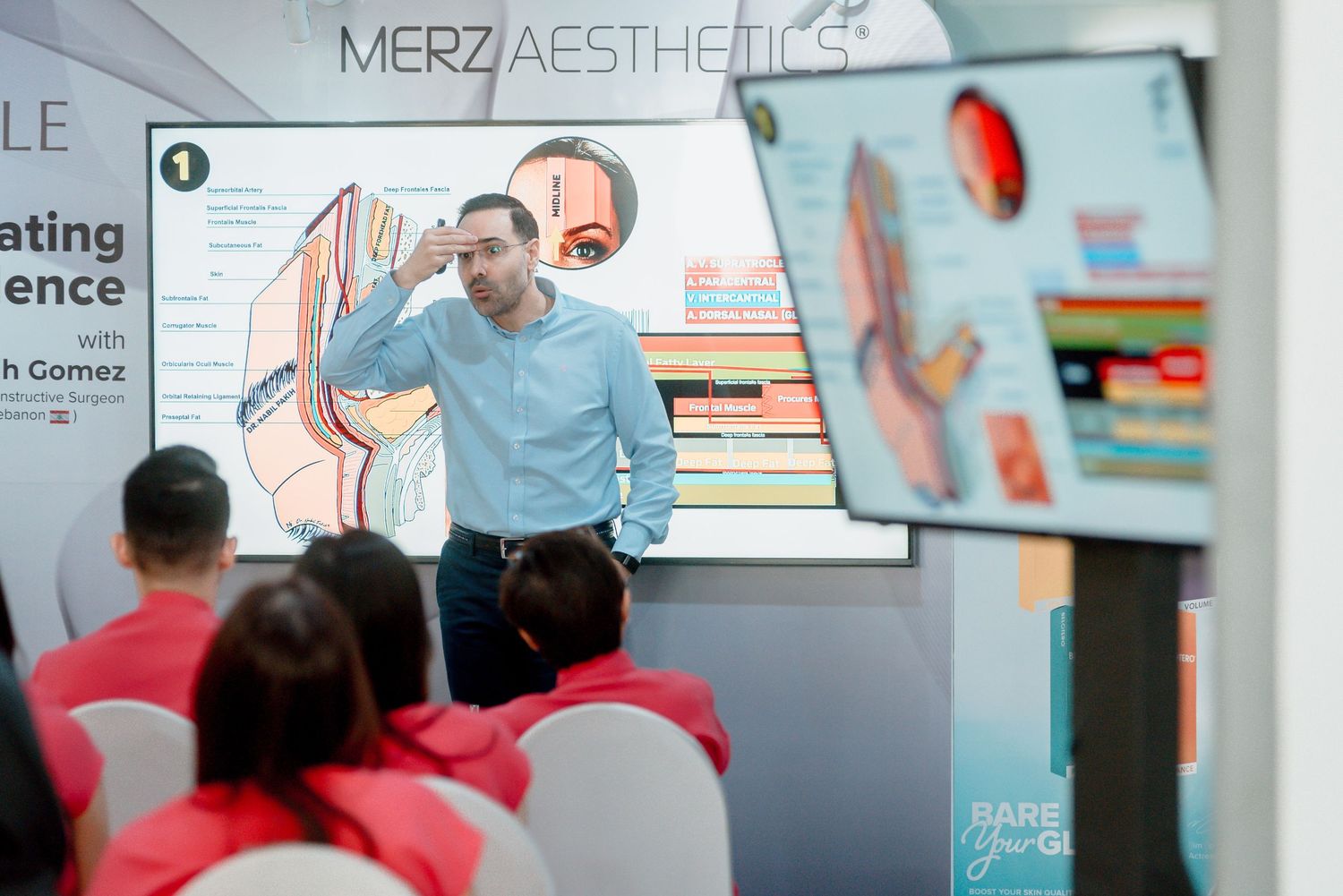 A medical professional gives a presentation about aesthetics to an audience in a classroom setting.