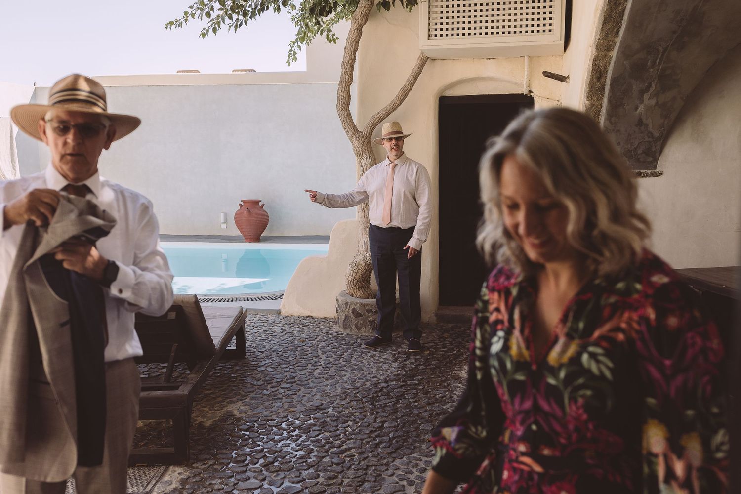 Three members of a destination wedding prepare to leave their apartment complex in Santorini.