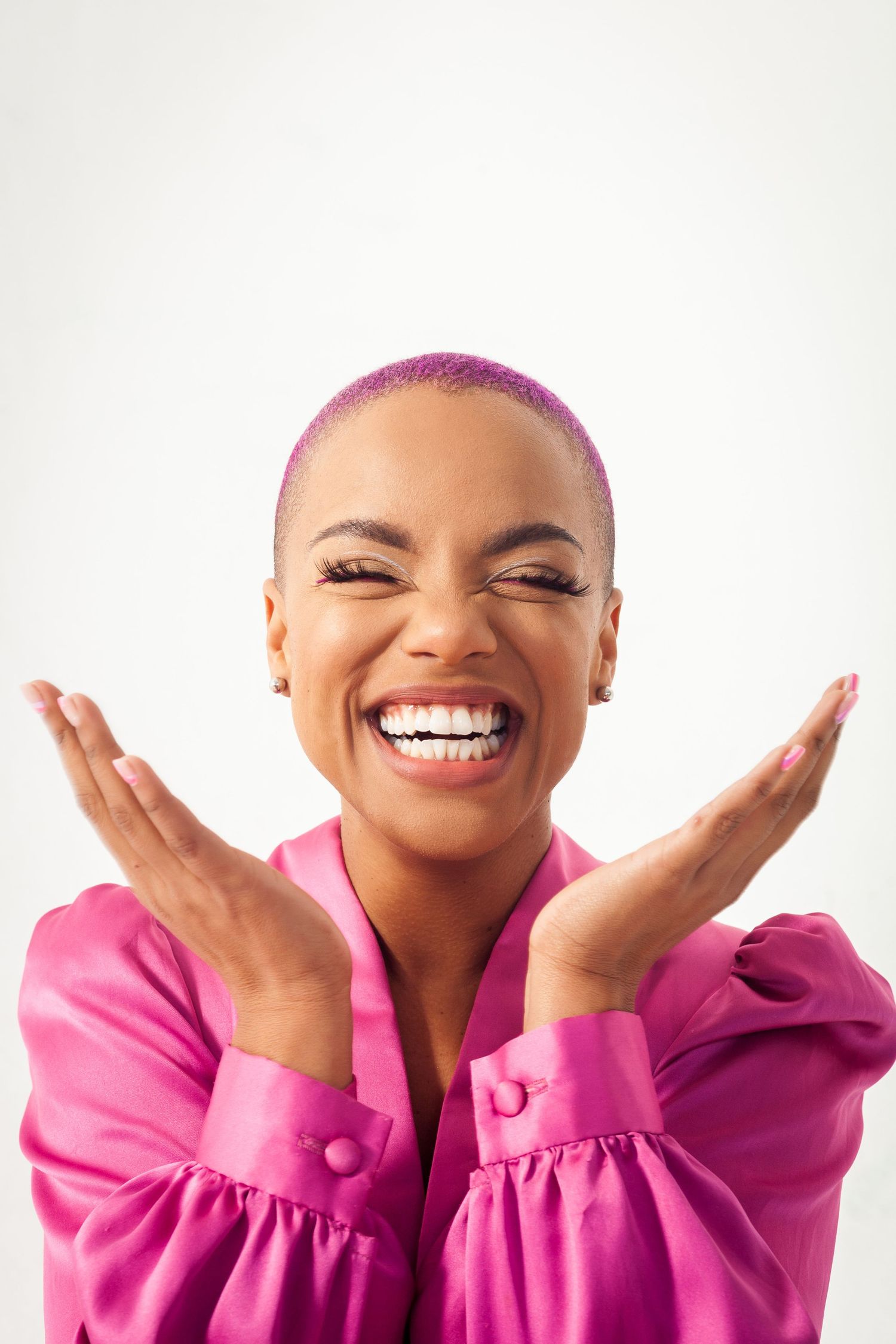 Joyful expressions and hand gestures wearing a bright pink top against white background.