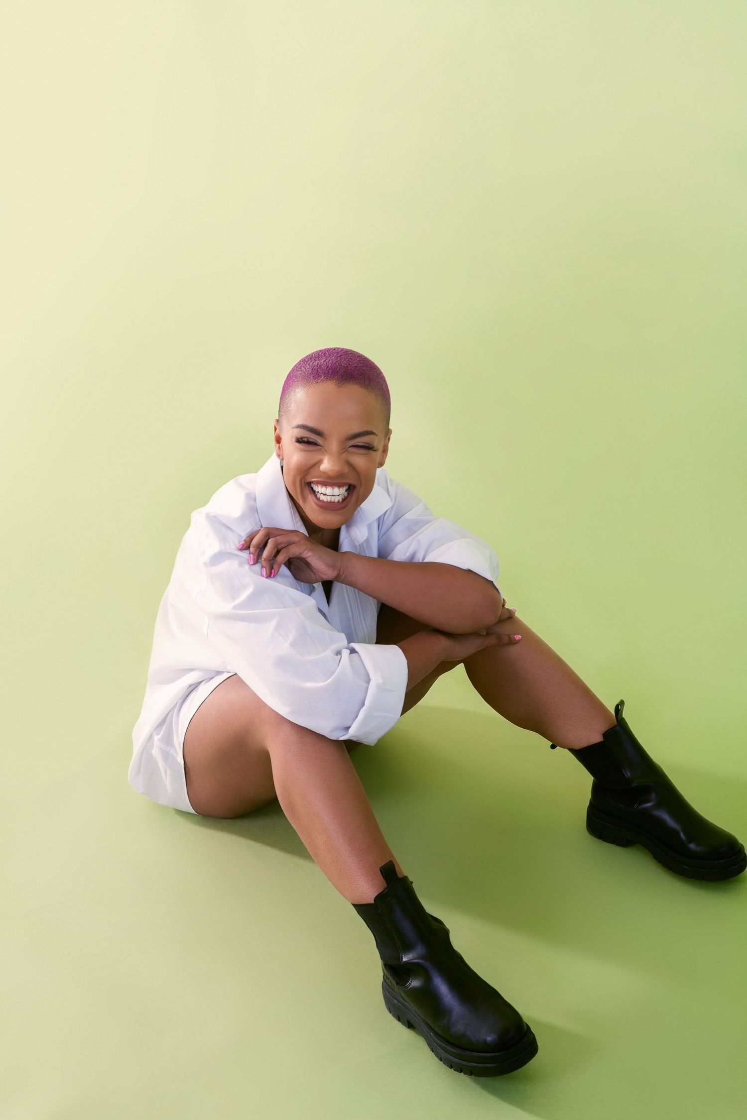 Playful poses on a mint green background wearing white clothing and black boots.