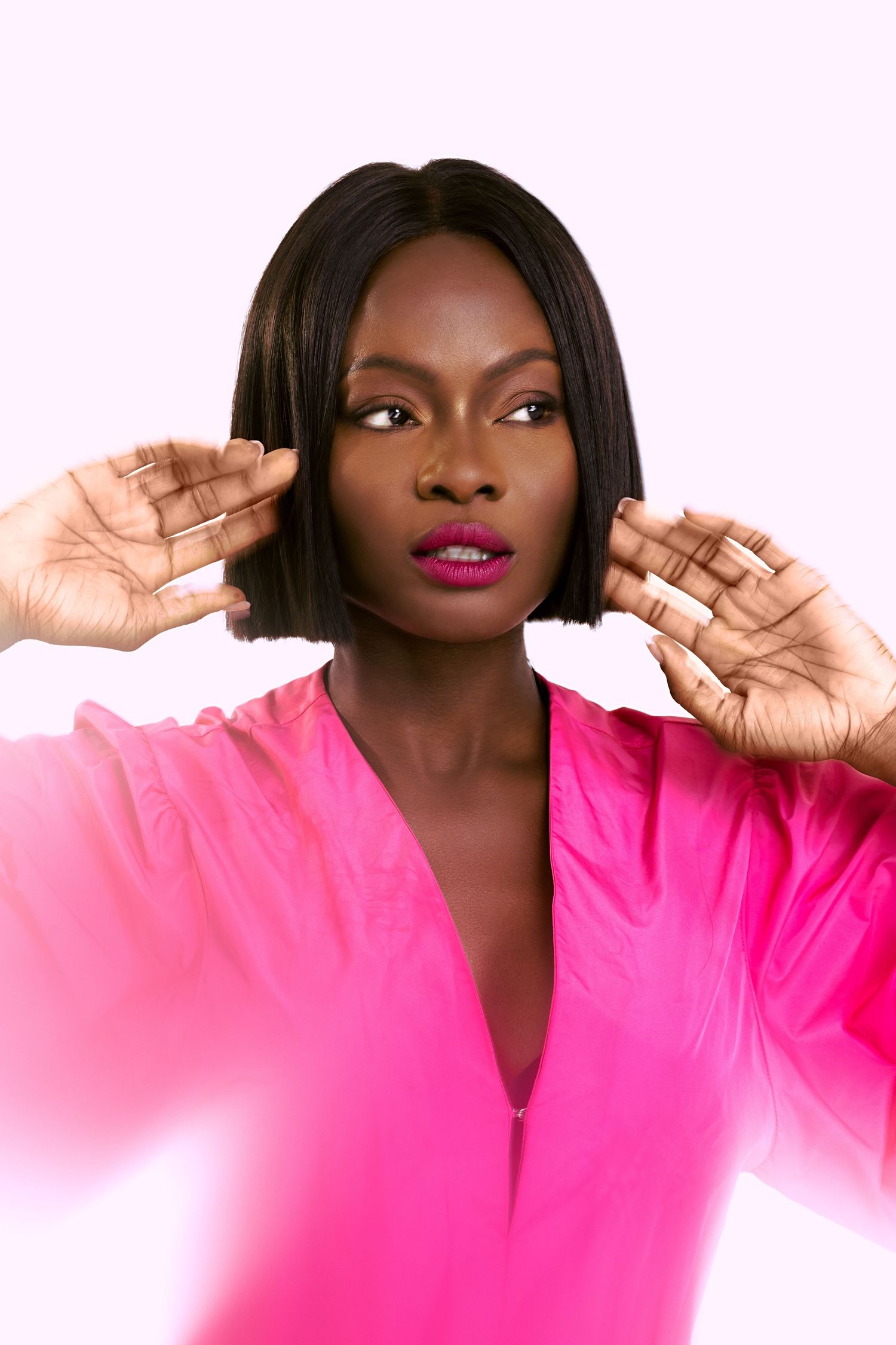 Expressive poses in a bright pink top against a white background.