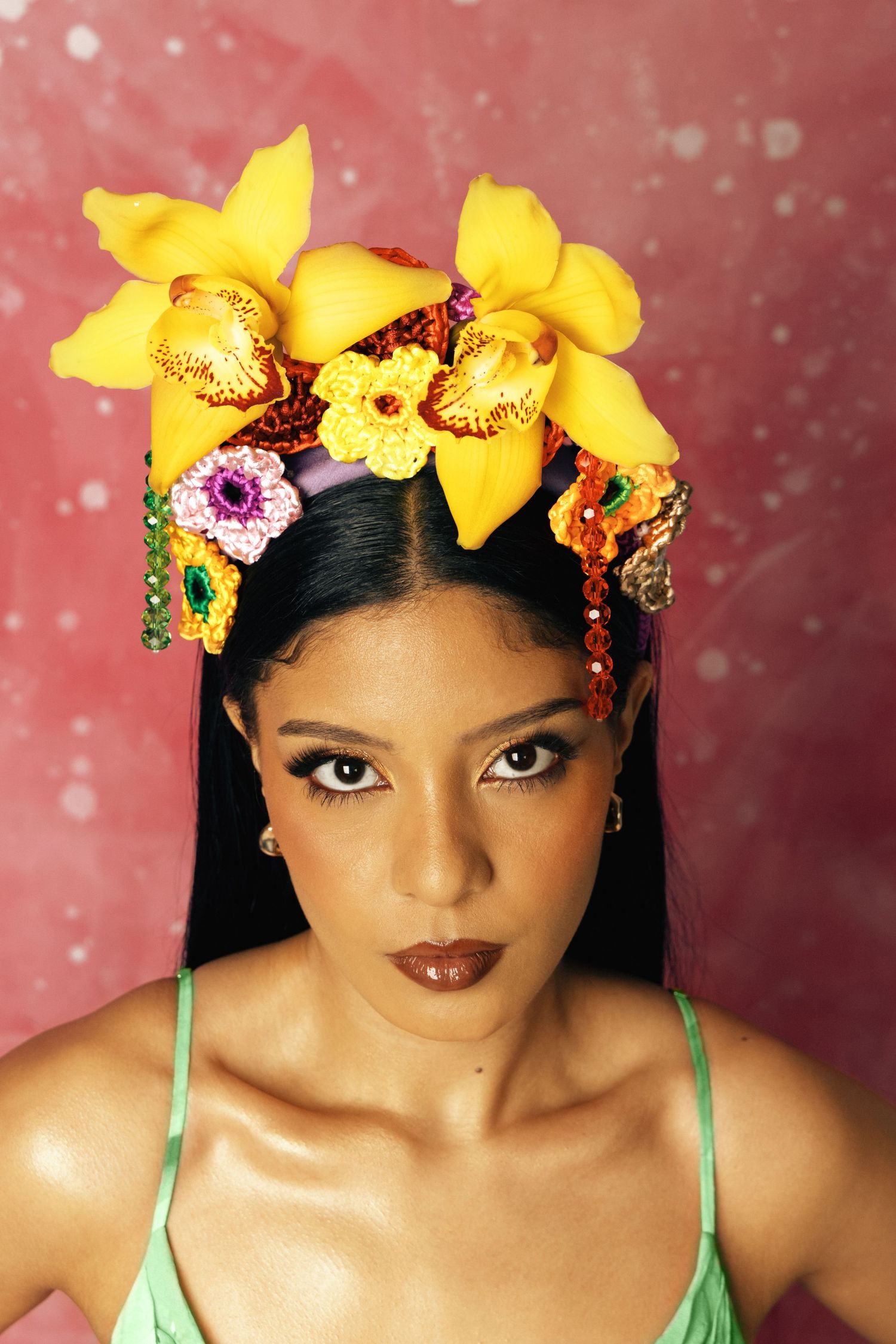 Artistic portraits with yellow orchid crown against pink sparkly backdrop.