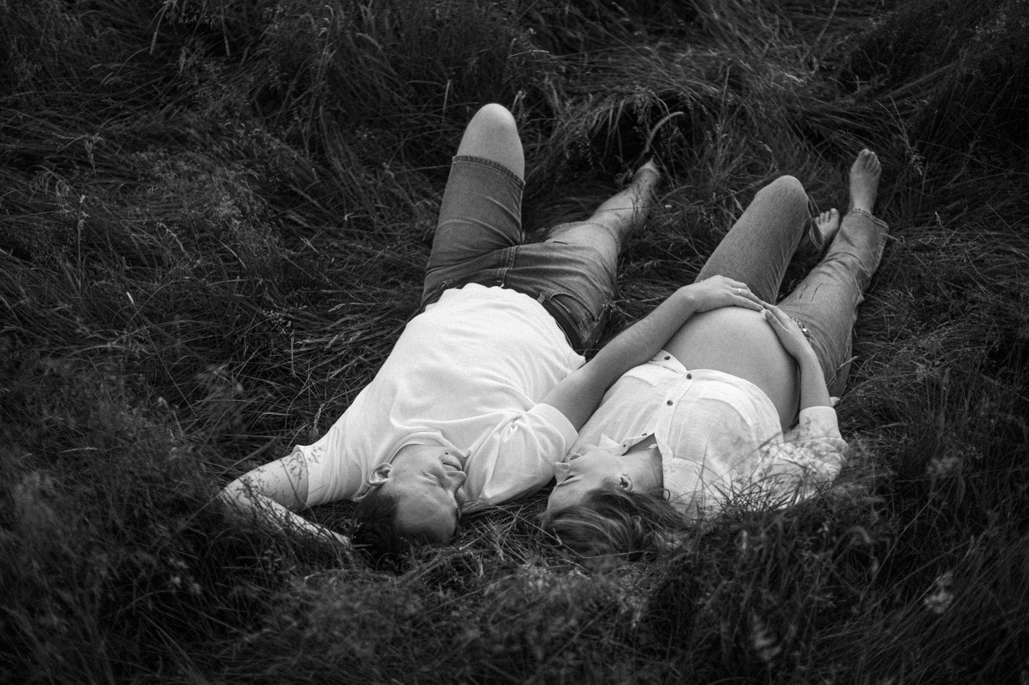 A black and white photo montage shows people lying down in grass and fields in various relaxed poses.