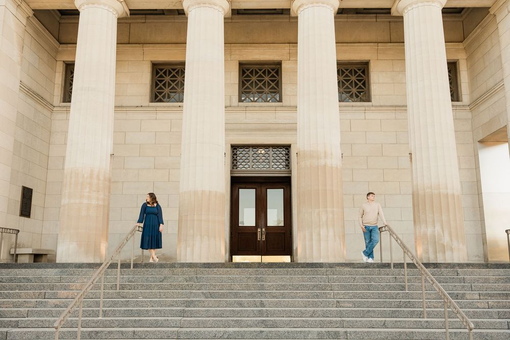 Elegant stone colonnade with classical architecture and steps leading to grand entrance.
