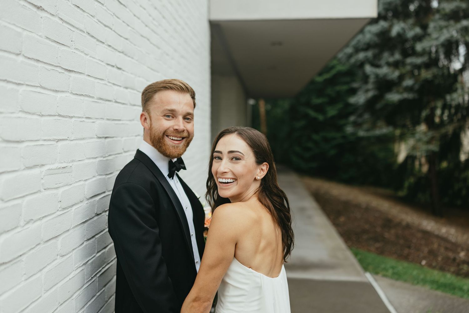 Smiling Wedding couple against a wall in Scarsdale, NY