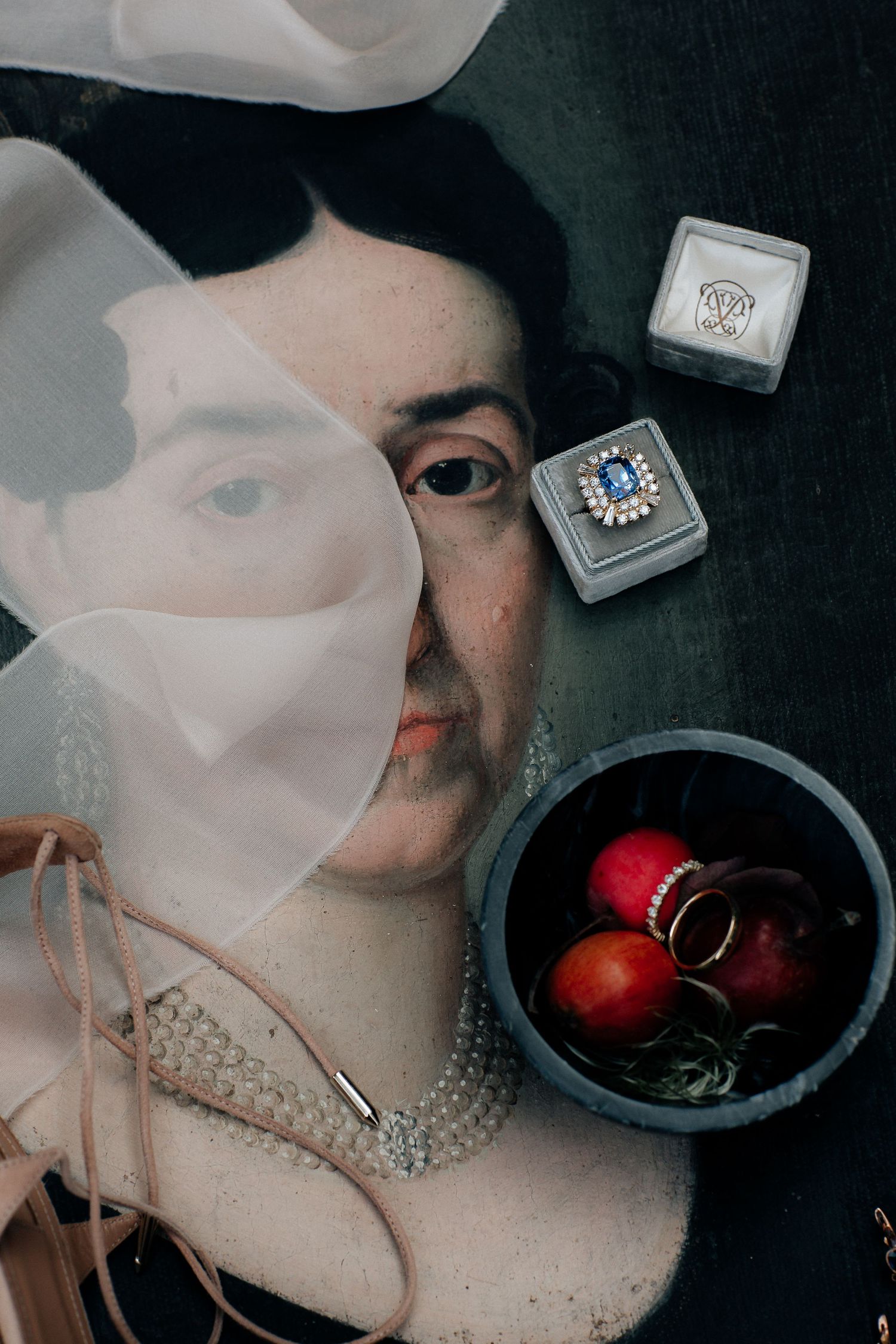 A series of dark, moody photographs showing someone wearing a white medical mask with decorative crystals next to red fruit.