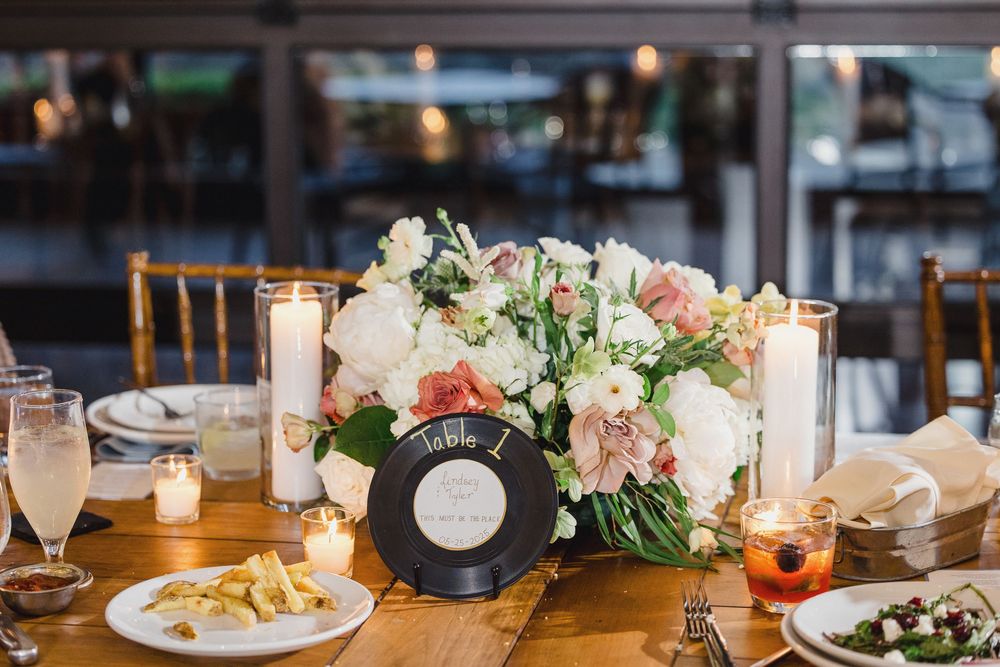 Wedding reception table settings with elegant floral centerpieces and glowing candles.