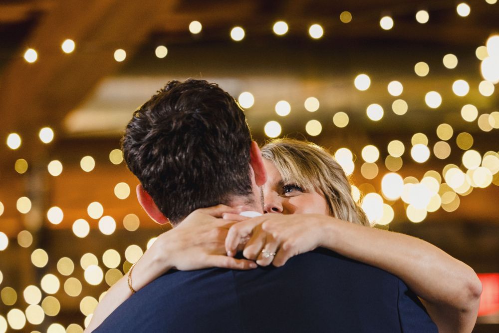 String lights create a romantic ambiance as couples dance together at an evening celebration.
