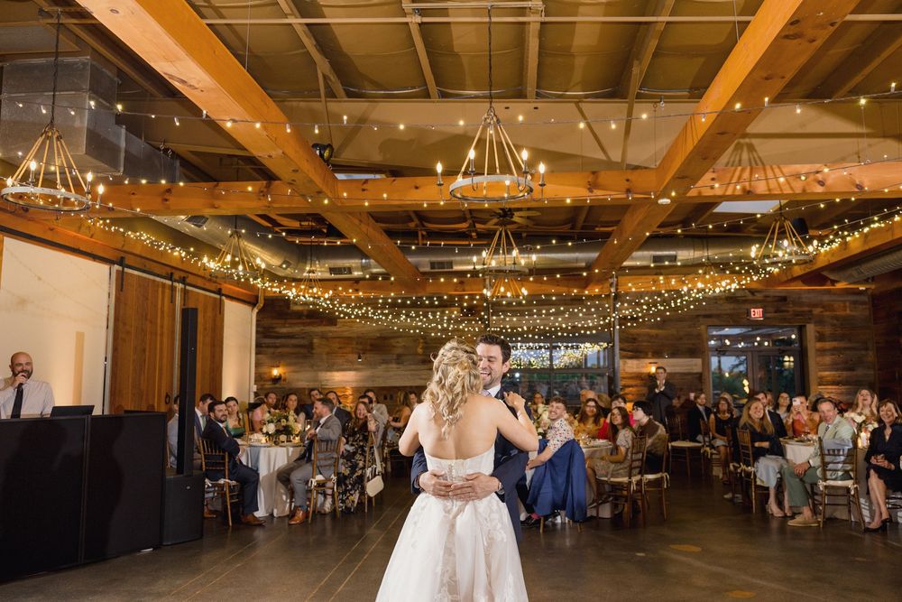 Large wedding venue decorated with string lights creating a warm, romantic atmosphere.