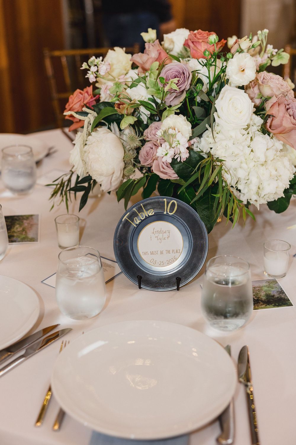 Elegant table setting with pink and white floral arrangements and numbered table markers.