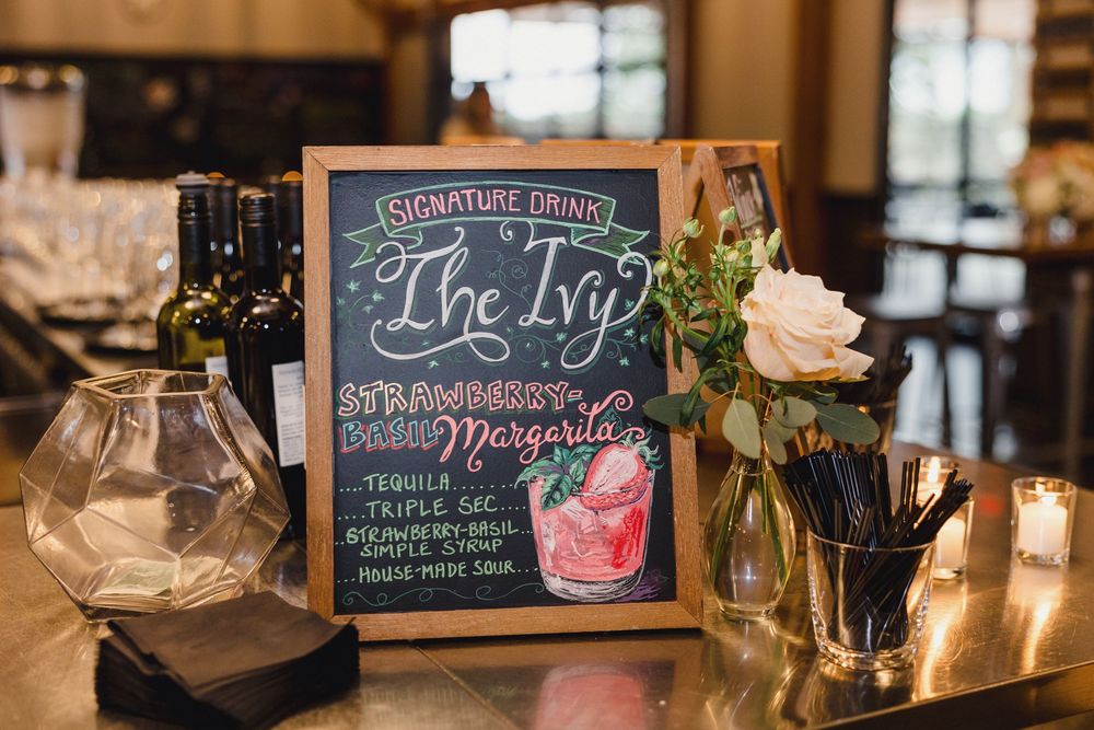 Bar menu displayed on chalkboards with specialty cocktail offerings.