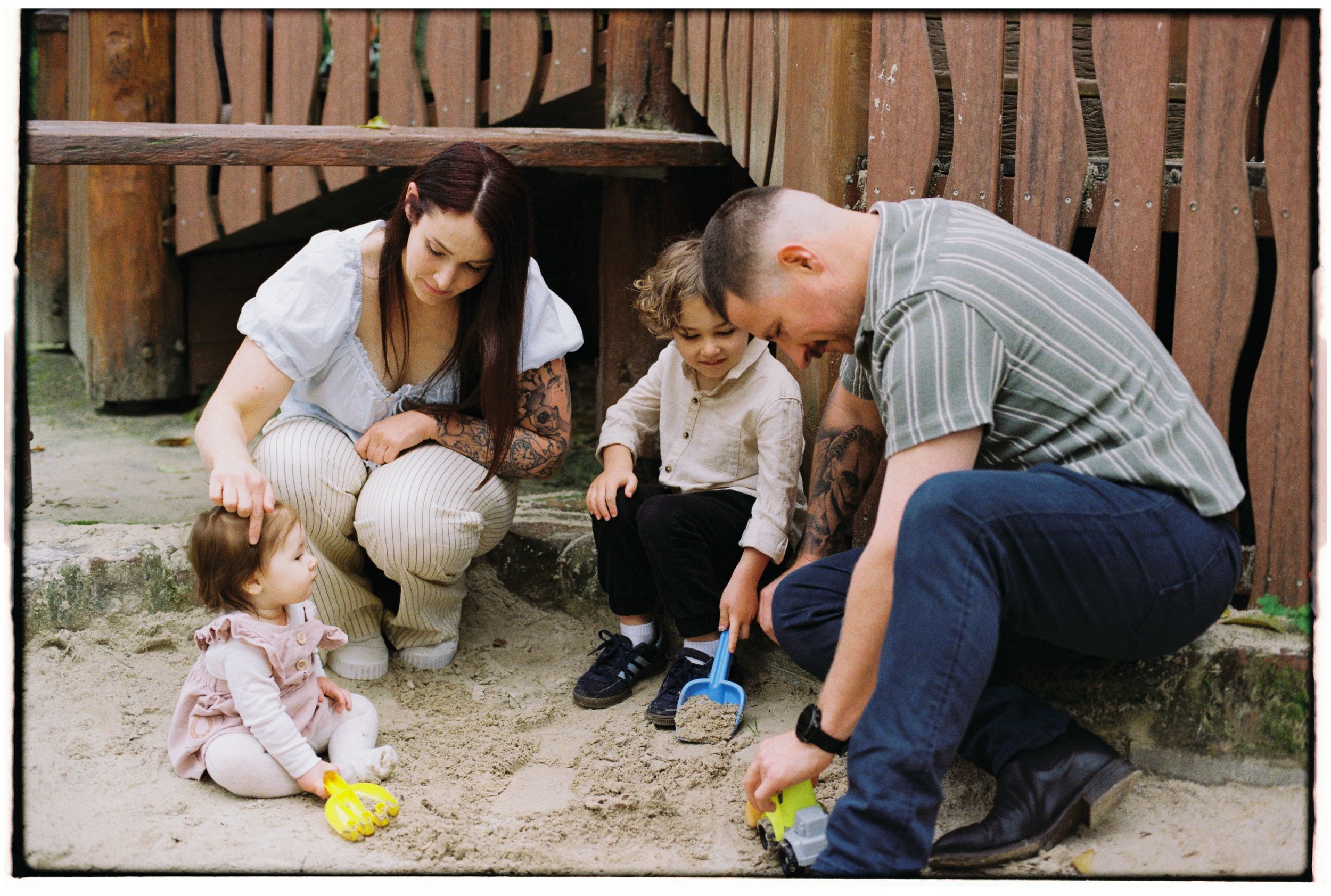 Family playing outside in sandpit captured on 35mm film