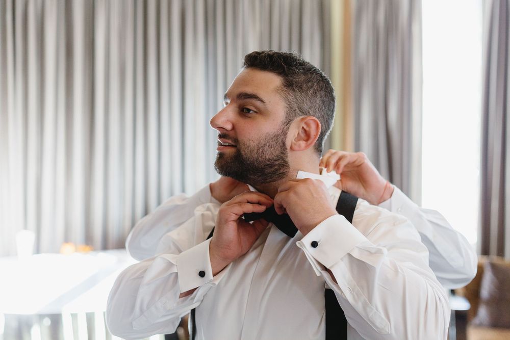 Wedding party members in white dress shirts and black ties preparing for the ceremony.