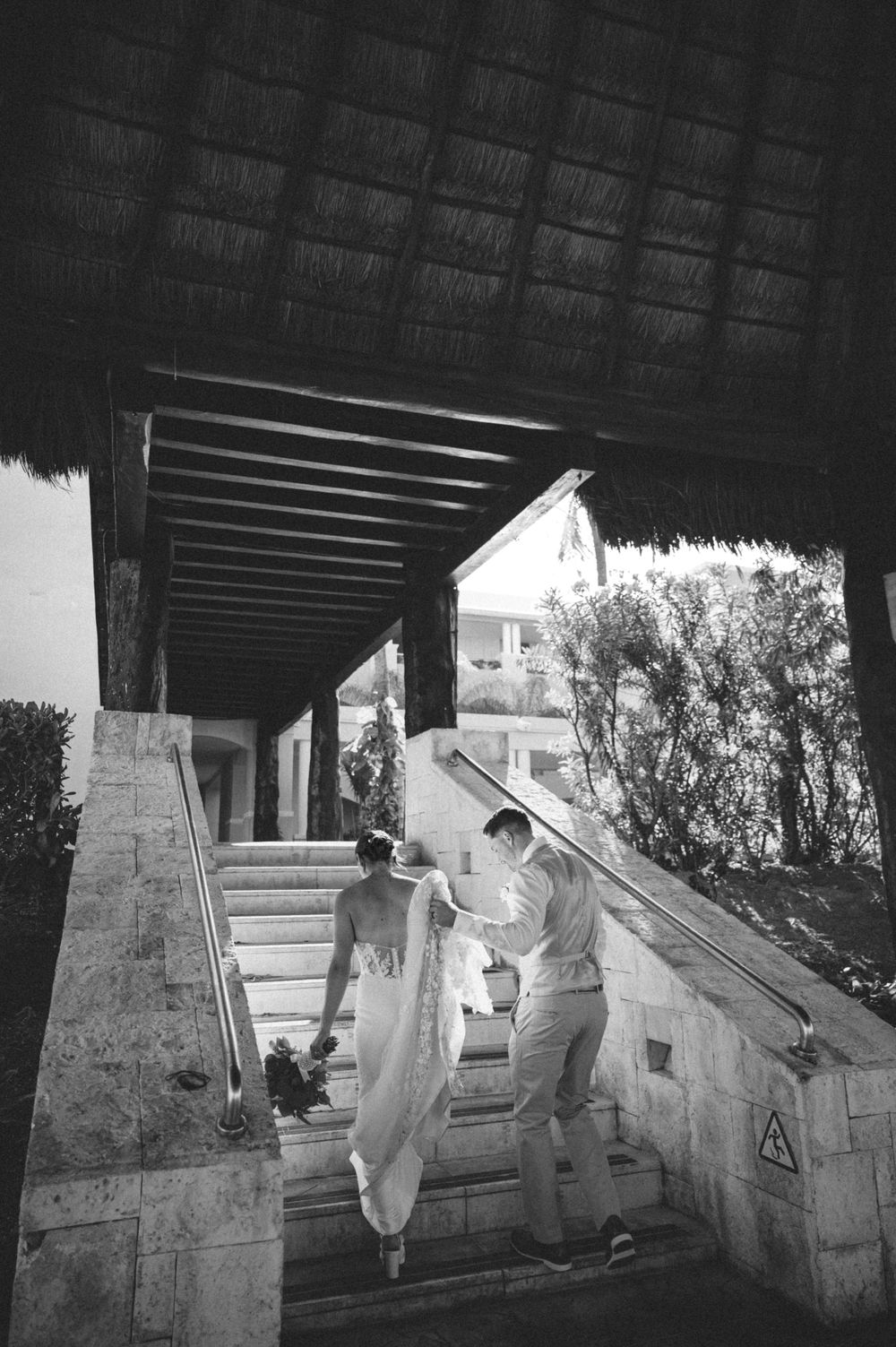 A sequence of black and white photos showing people in white protective suits working on a sloped surface.