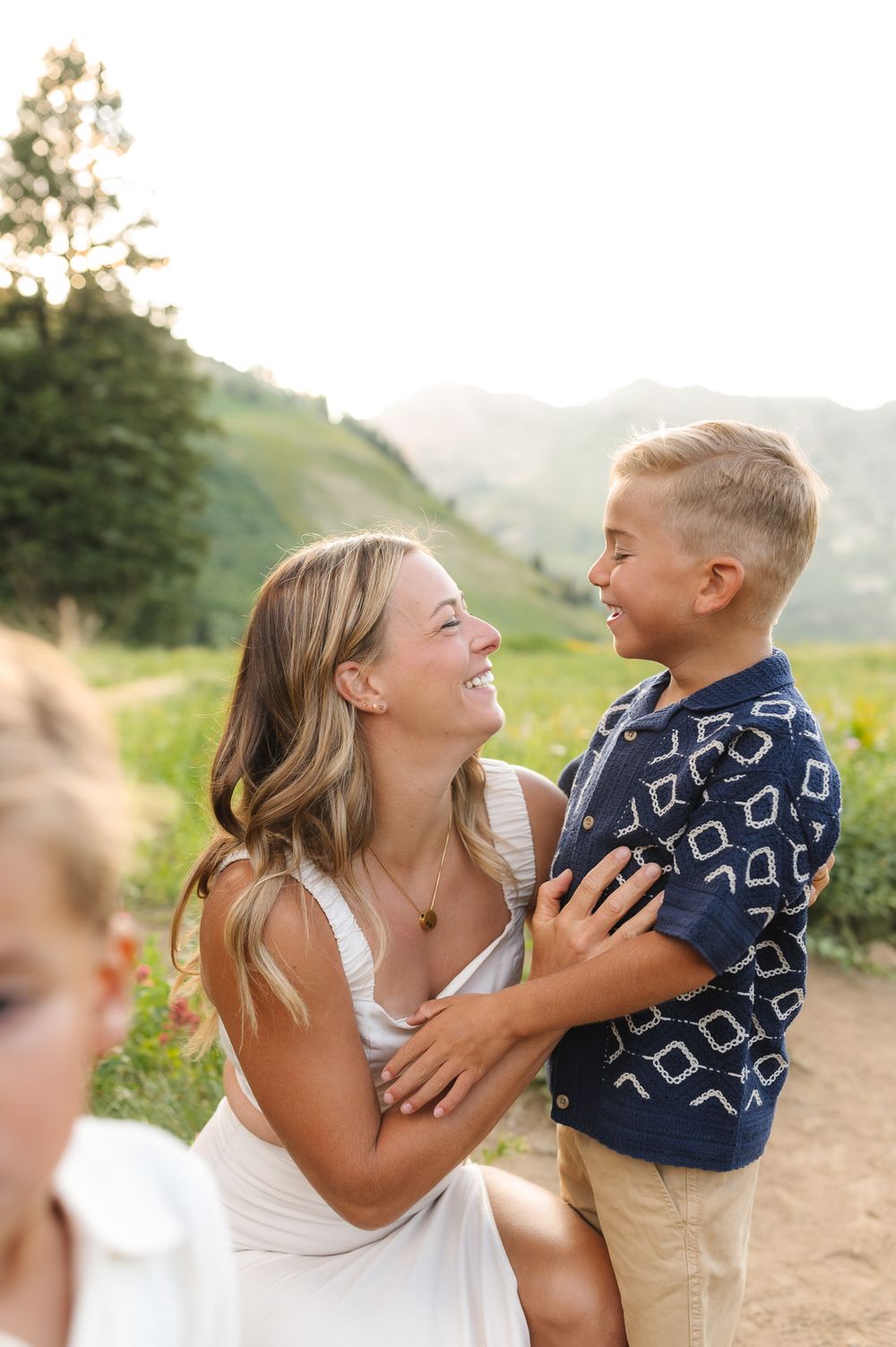 A joyful moment captured between mother and child playing outdoors in a natural setting with mountains in background at Albion Basin.
