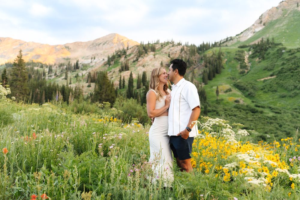 Romantic couple portraits in mountain wildflower field during golden hour.