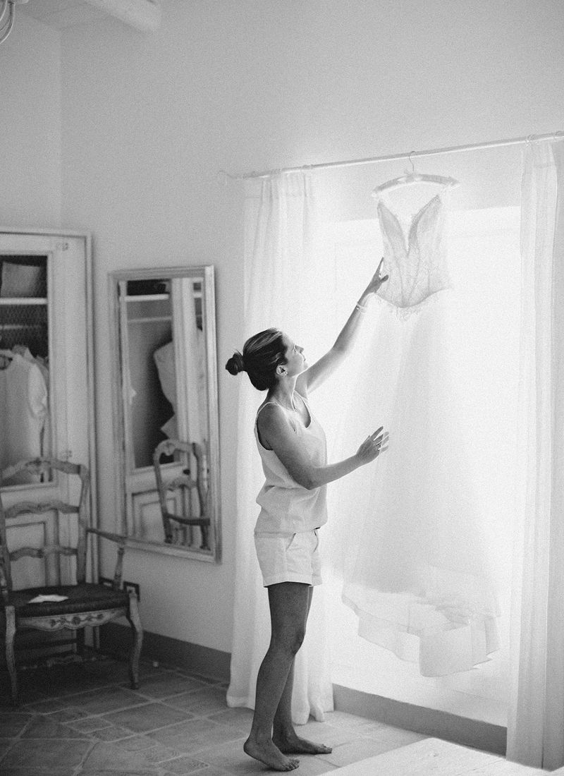 Bride lifting her wedding dress in a bright room while getting ready in piedmont