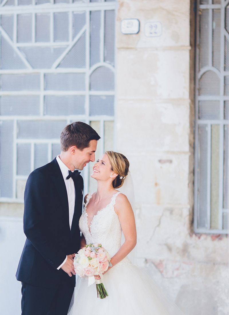 Bride and groom standing together outside La Villa Hotel in Mombaruzzo