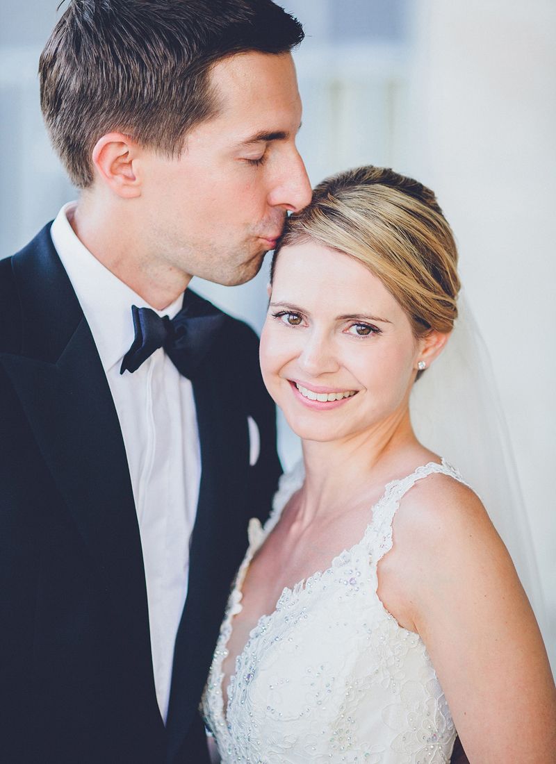 Groom kissing the bride on the forehead during their wedding day