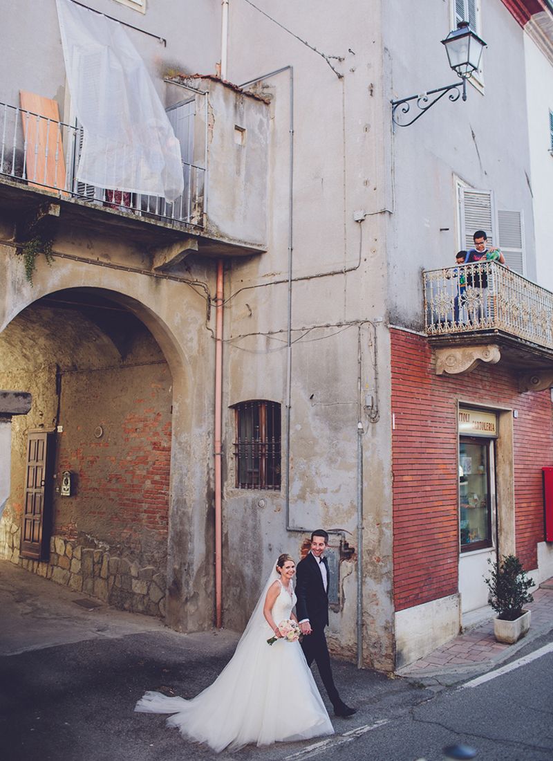 couple walking through  historic street of Mombaruzzo