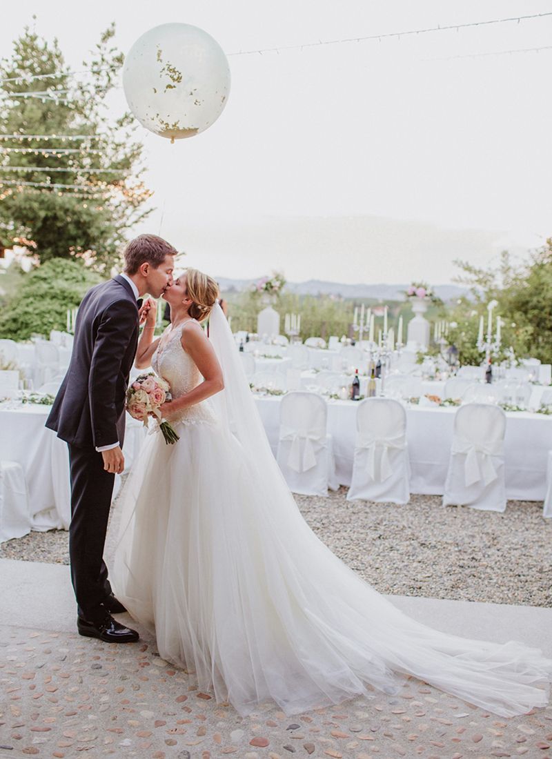 Bride and groom kissing at their outdoor wedding reception.