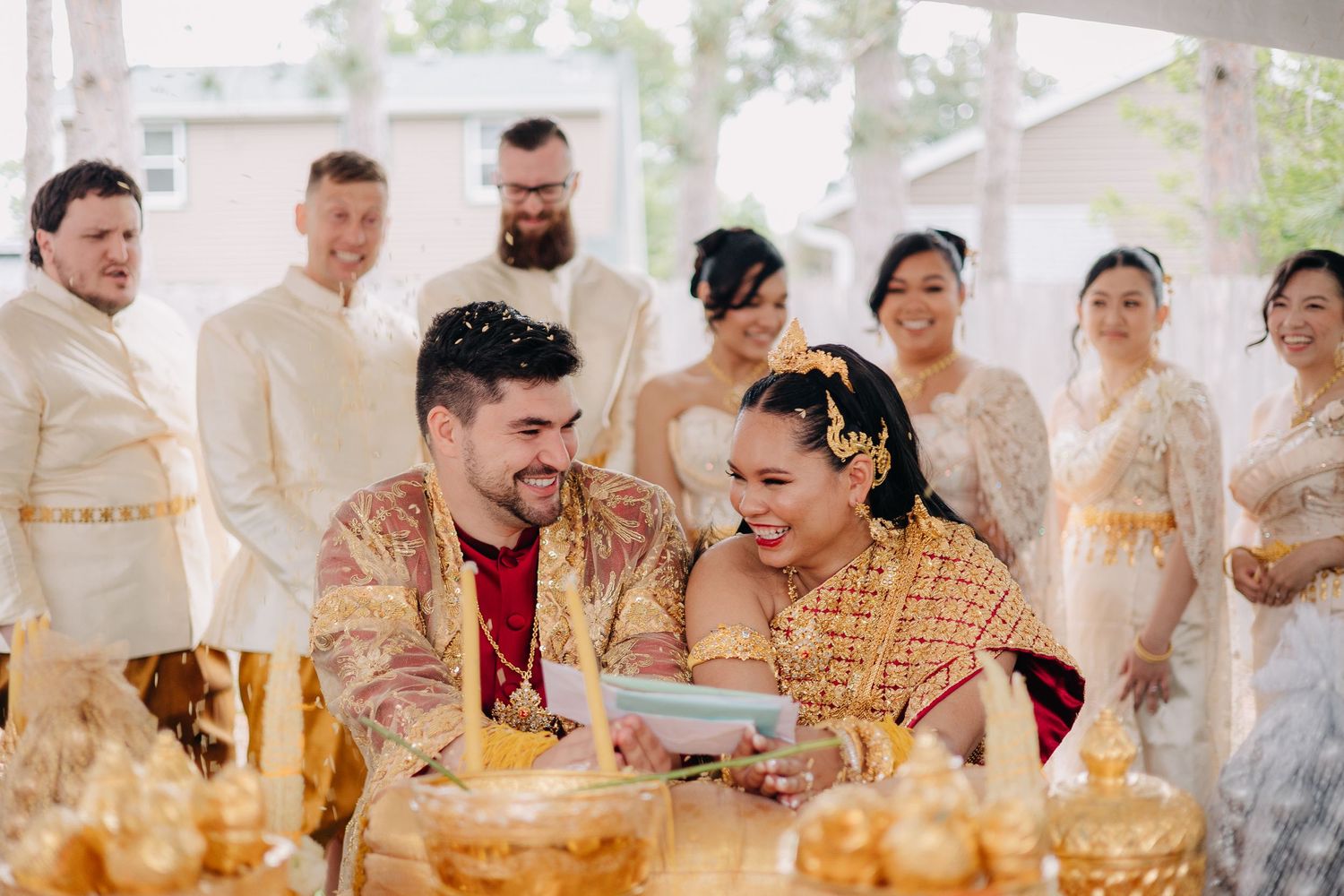 Traditional Thai wedding ceremony participants pour water blessings during a cultural ritual celebration.