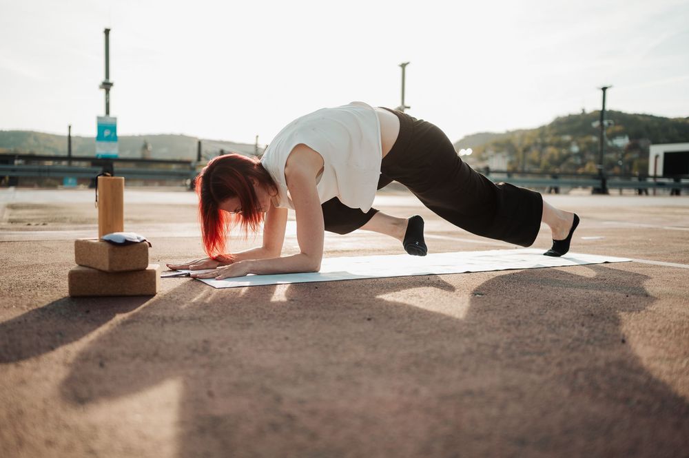 A sequence of fitness poses showing stretching and planking exercises on a sandy beach at sunset.