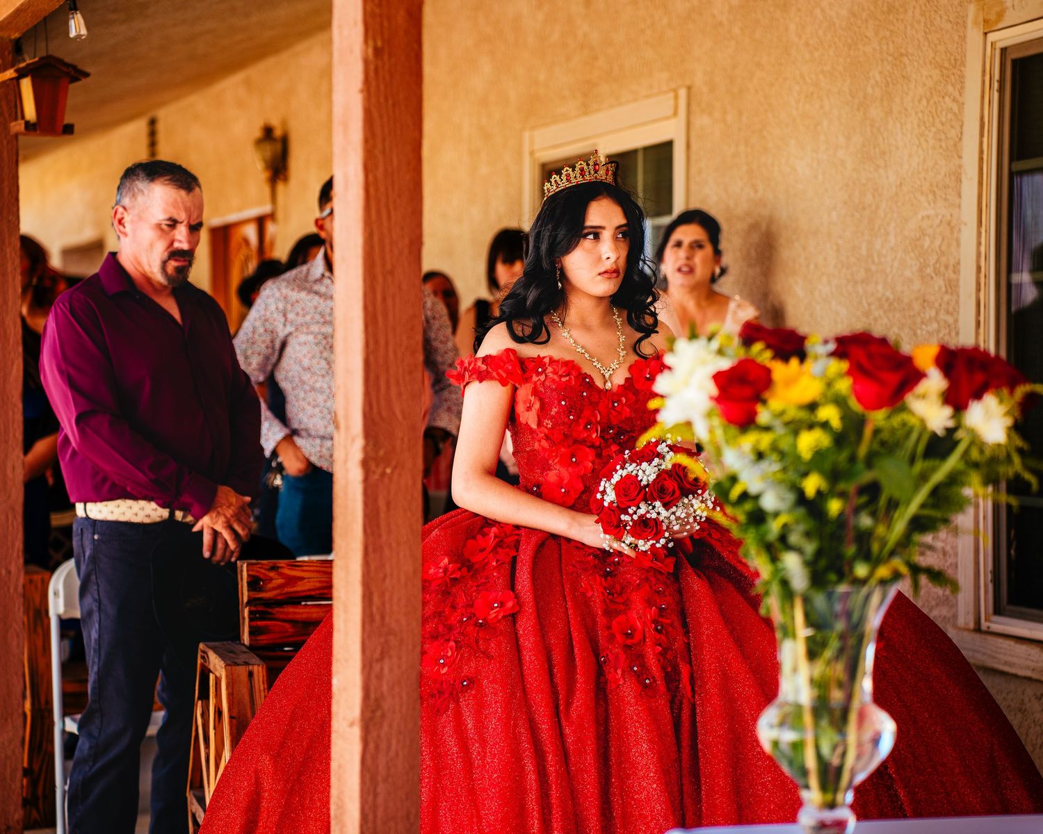 Wedding party members in red formal dresses dance and celebrate during an elegant evening reception.