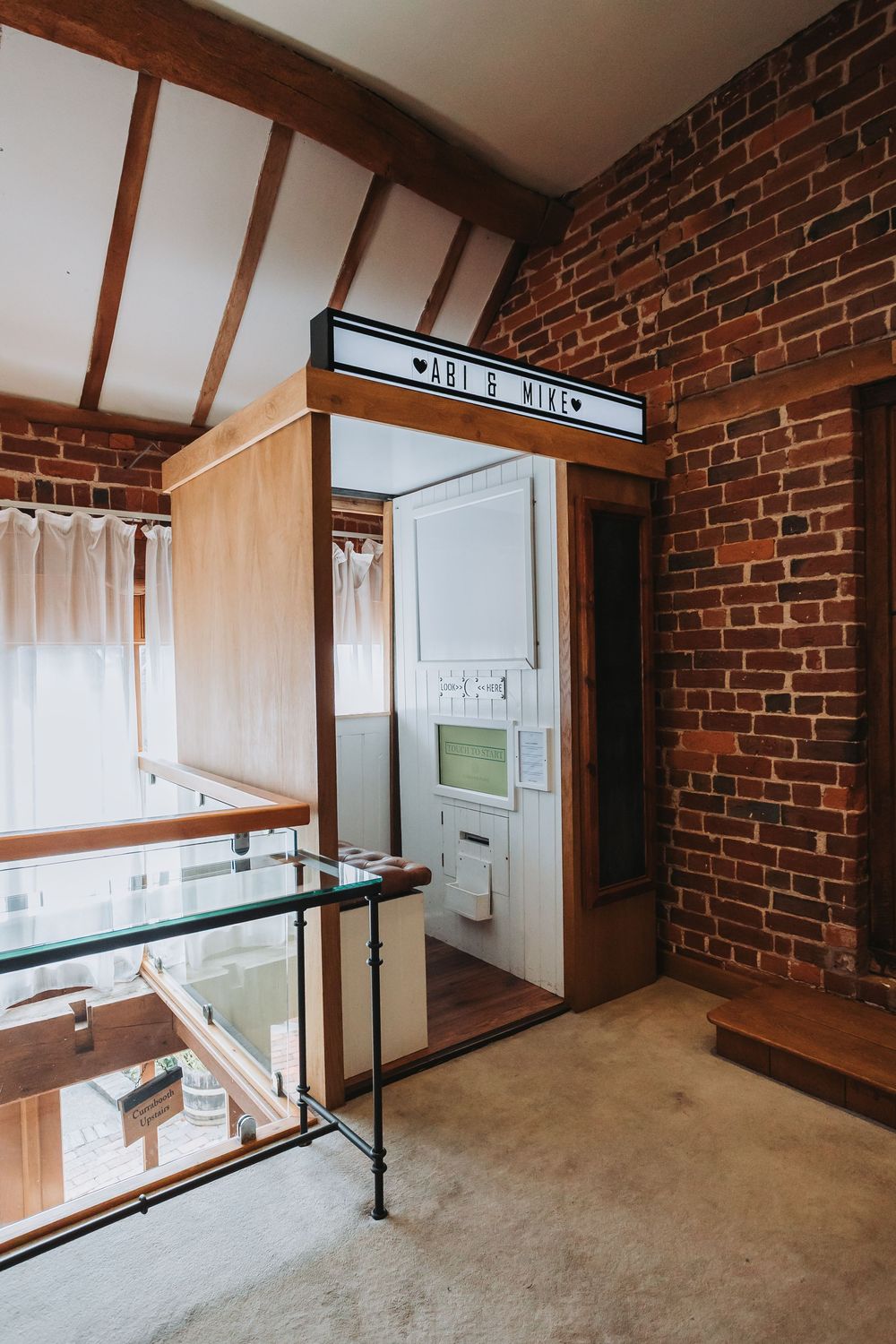 Modern loft space with exposed brick walls, wooden beams, and large windows showcasing natural light and minimalist design.