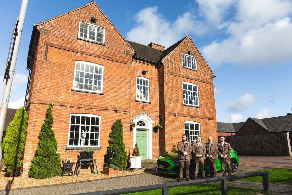 Red brick Georgian-style building exterior with white-framed windows and landscaped grounds.