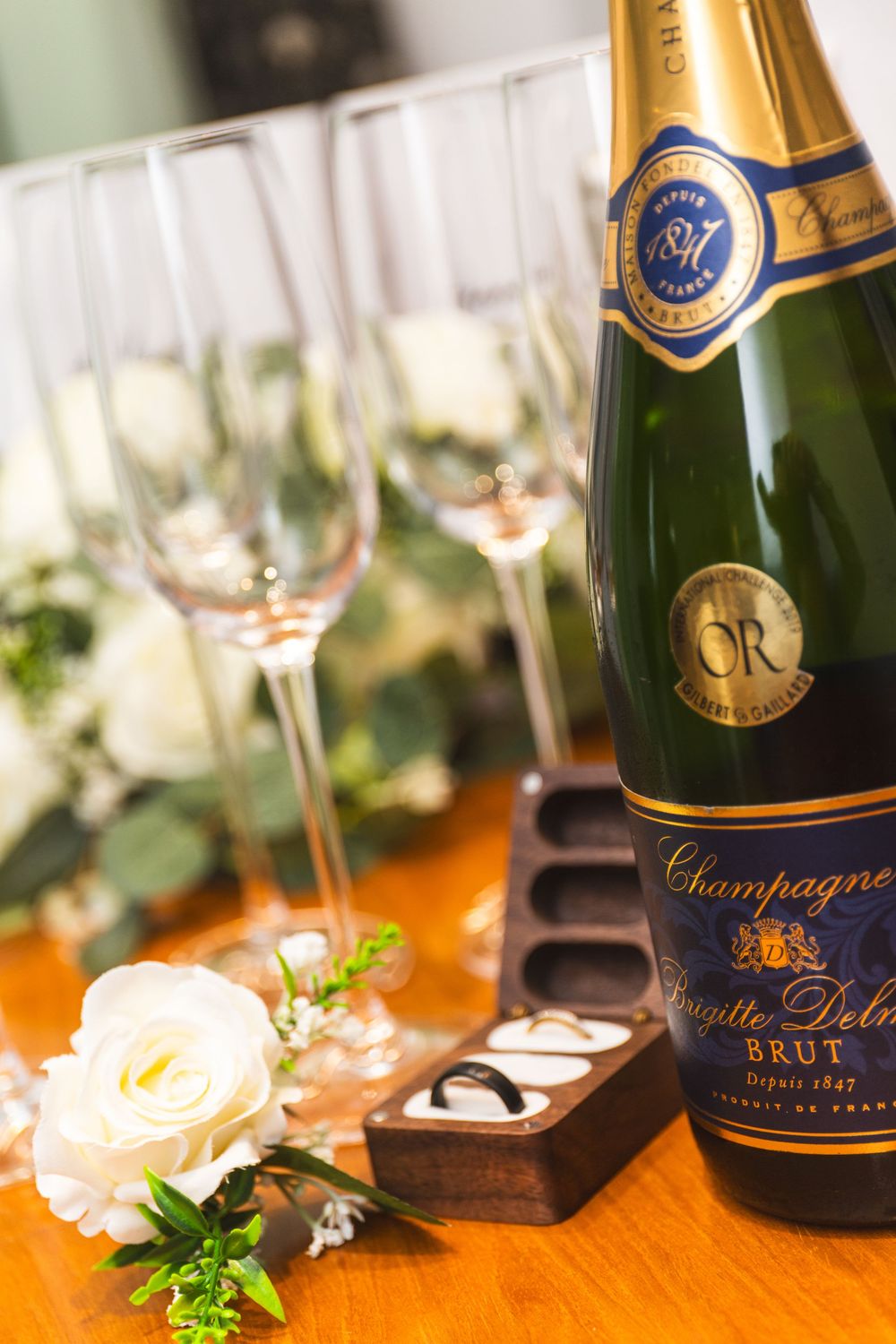 Elegant champagne bottles and floral decorations arranged on a wooden table for a special celebration.
