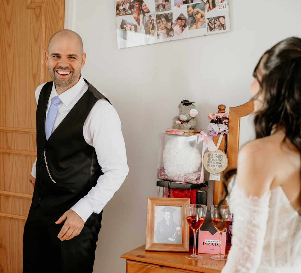 A series of wedding photos showing emotional first look reactions between a couple in a rustic indoor setting.