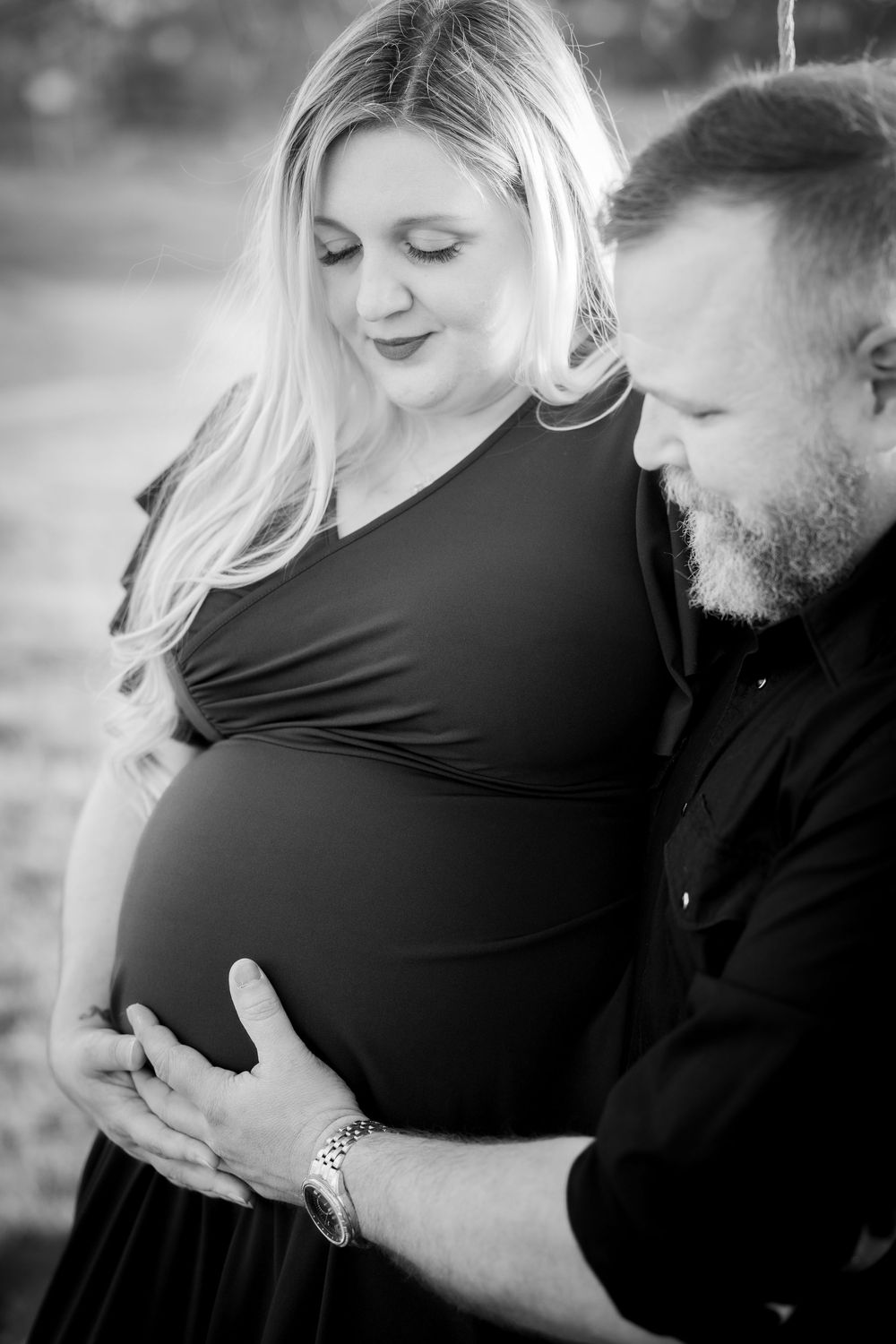 Black and white maternity photography series capturing tender moments between expectant parents.