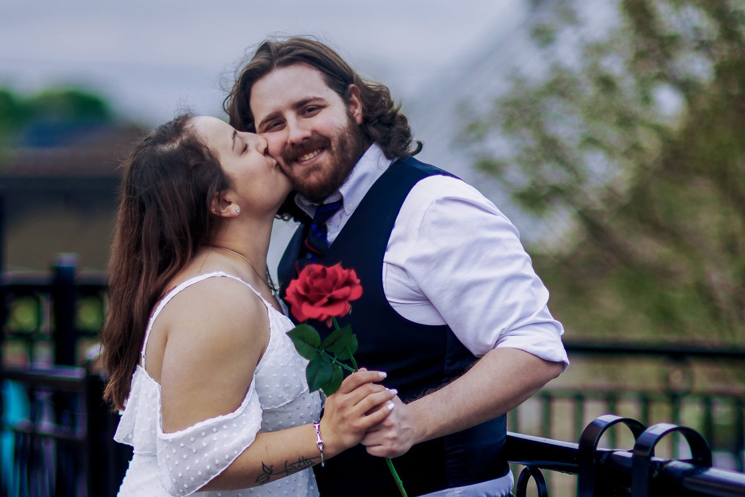 A couple shares a romantic moment dancing together during their outdoor wedding celebration.