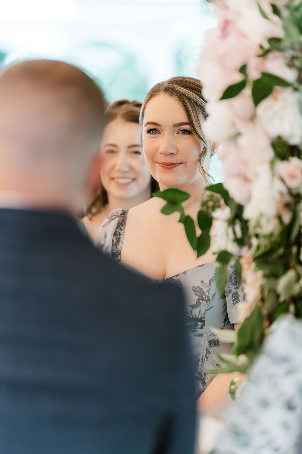 Soft focus wedding ceremony scene with floral decorations and pink blossoms.