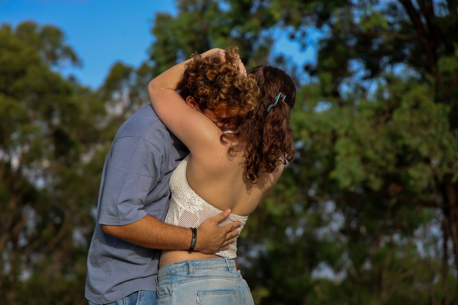 A couple hugging each other while the sun beams down creating a vibrant light