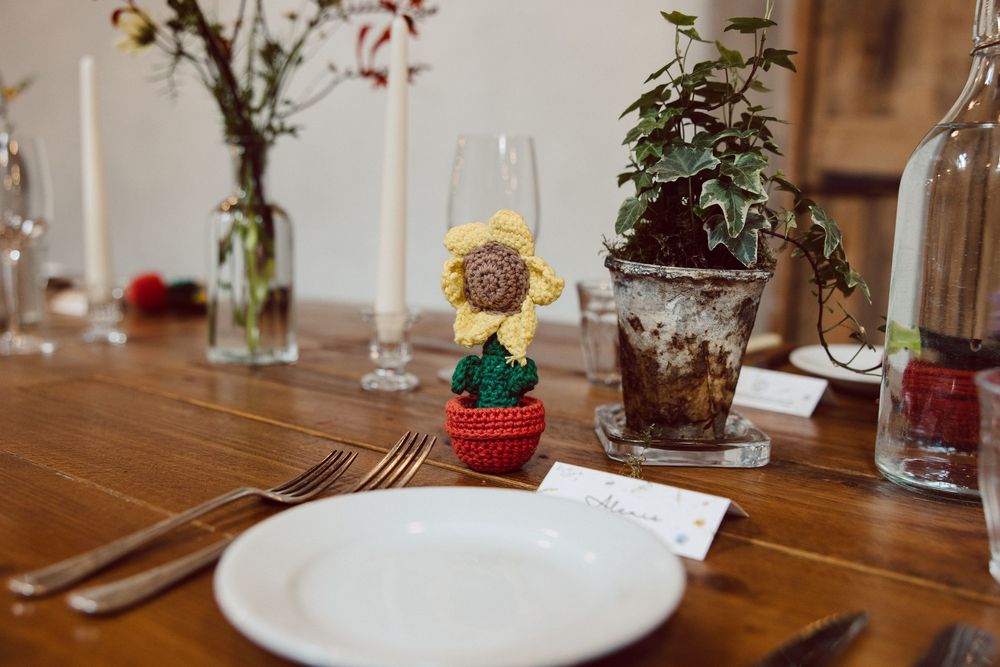 Elegant table setting at a rustic wedding reception with glass terrariums and floral centerpieces.