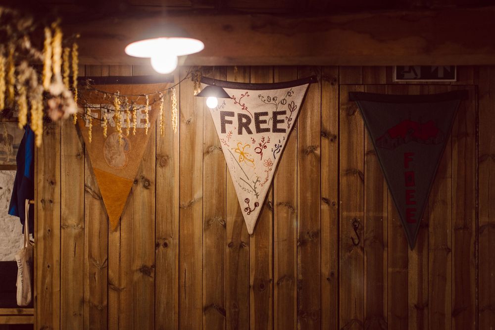 A rustic wooden wall with vintage decor and a 'FREE' sign illuminated by a ceiling light fixture.