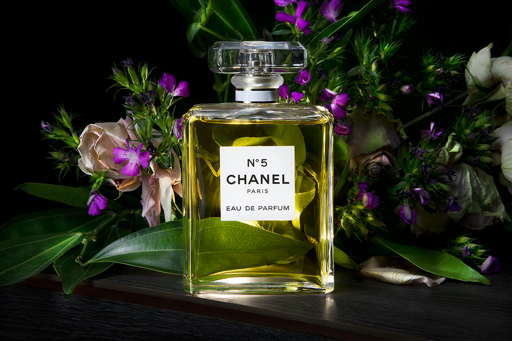 Product photography featuring a cologne bottle with a floral background, created by commercial photographer Chris Z of Zeng Studio.