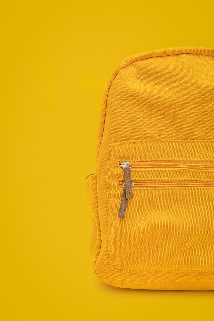 Product photography featuring a yellow backpack on a yellow background, created by commercial photographer Chris Z of Zeng Studio.
