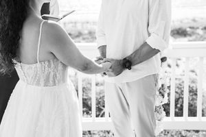 A black and white close-up of joined hands during a wedding ceremony.
