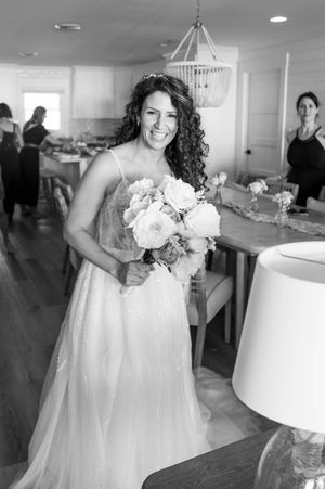 A joyful moment captured in black and white during an indoor wedding celebration.